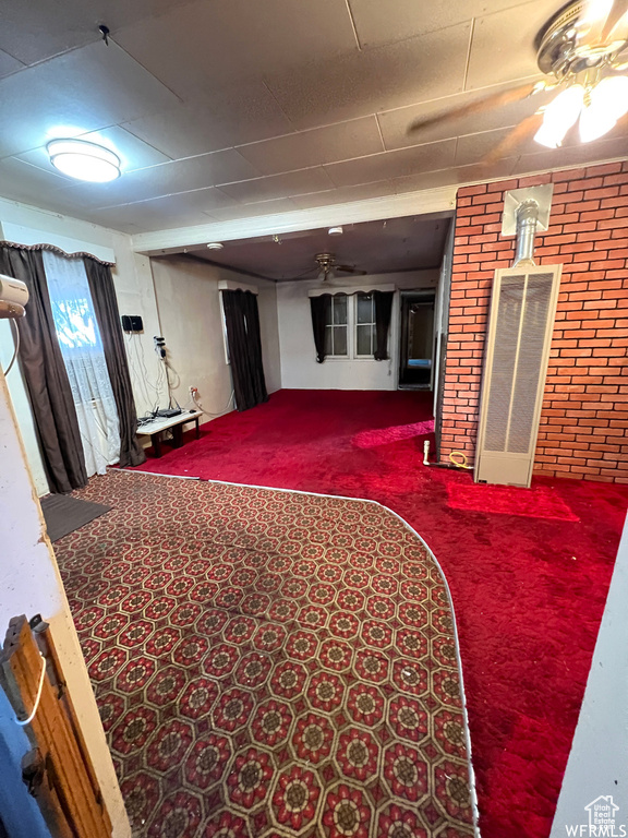 Carpeted bedroom with brick wall and ceiling fan