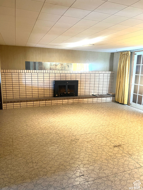 Unfurnished room featuring a brick fireplace and tile flooring