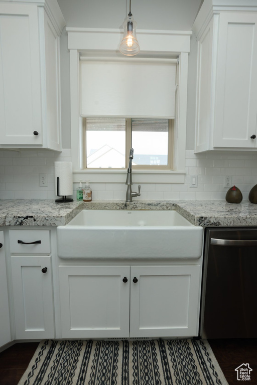 Kitchen featuring dishwasher, tasteful backsplash, and white cabinetry
