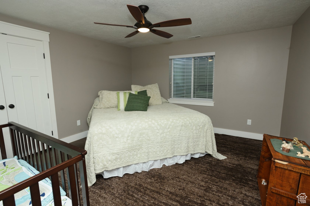 Bedroom with a textured ceiling and ceiling fan