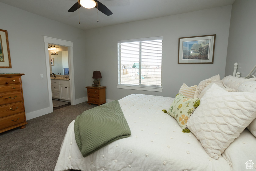 Carpeted bedroom with connected bathroom and ceiling fan