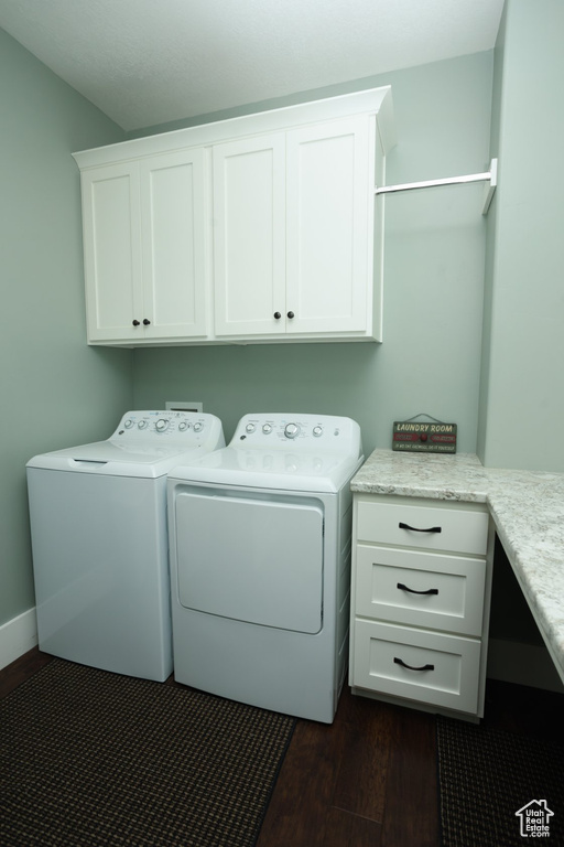 Washroom featuring independent washer and dryer, dark hardwood / wood-style floors, and cabinets
