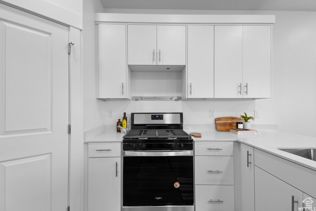 Kitchen featuring stainless steel range with gas stovetop and white cabinetry