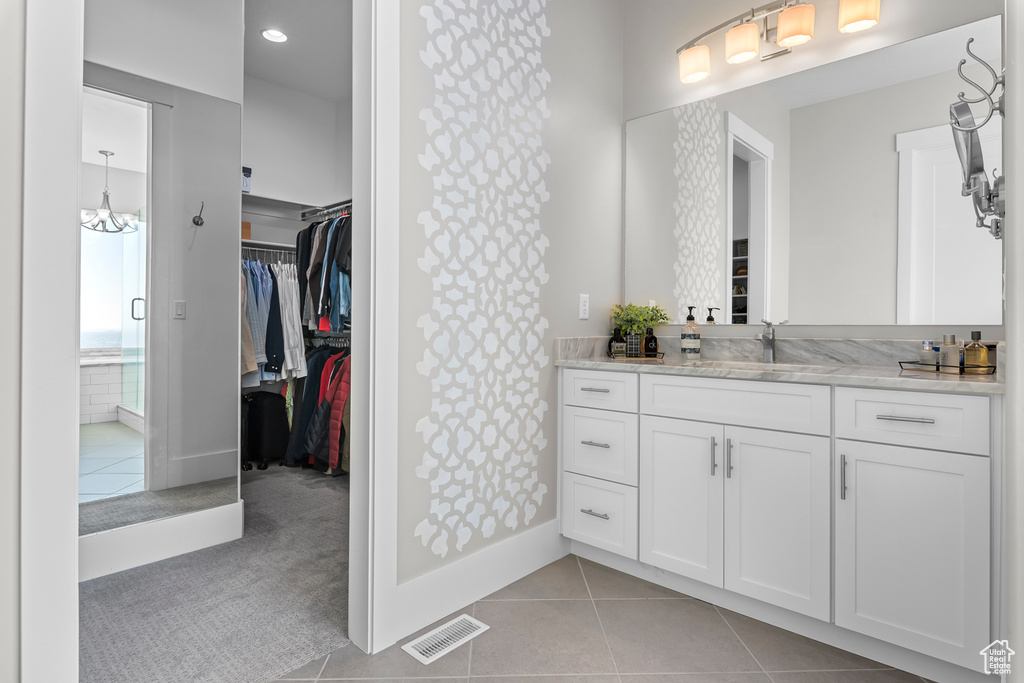 Bathroom featuring vanity, tile floors, and a chandelier