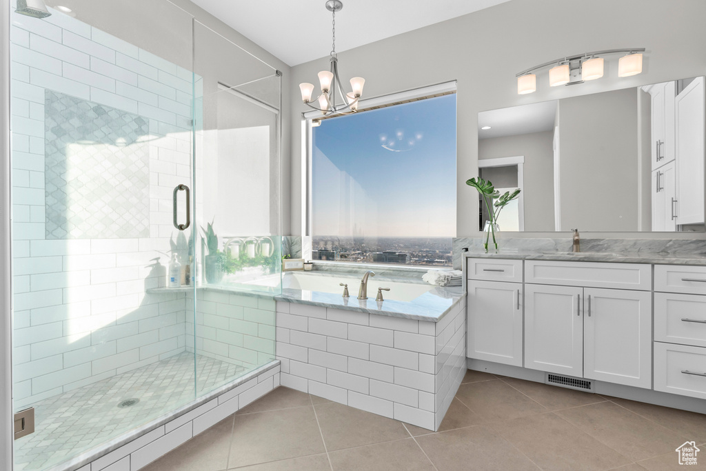 Bathroom featuring a notable chandelier, plus walk in shower, vanity, and tile floors
