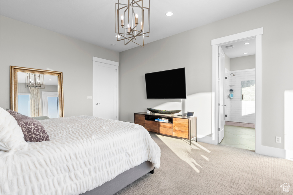 Bedroom with ensuite bathroom, light carpet, and a notable chandelier