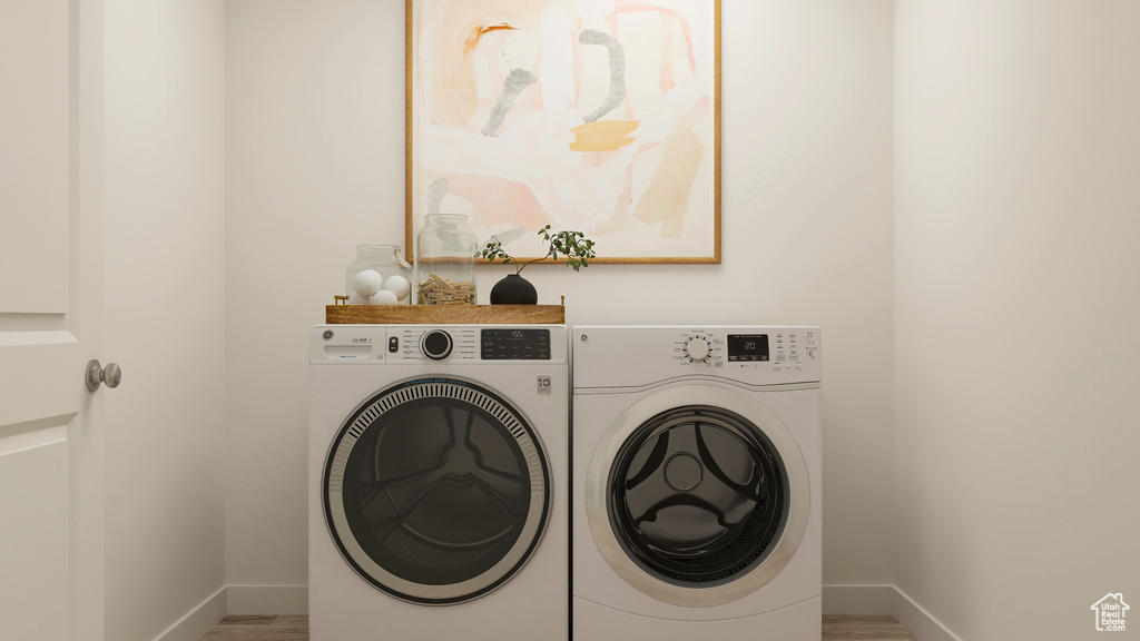 Laundry area with washing machine and clothes dryer and hardwood / wood-style floors