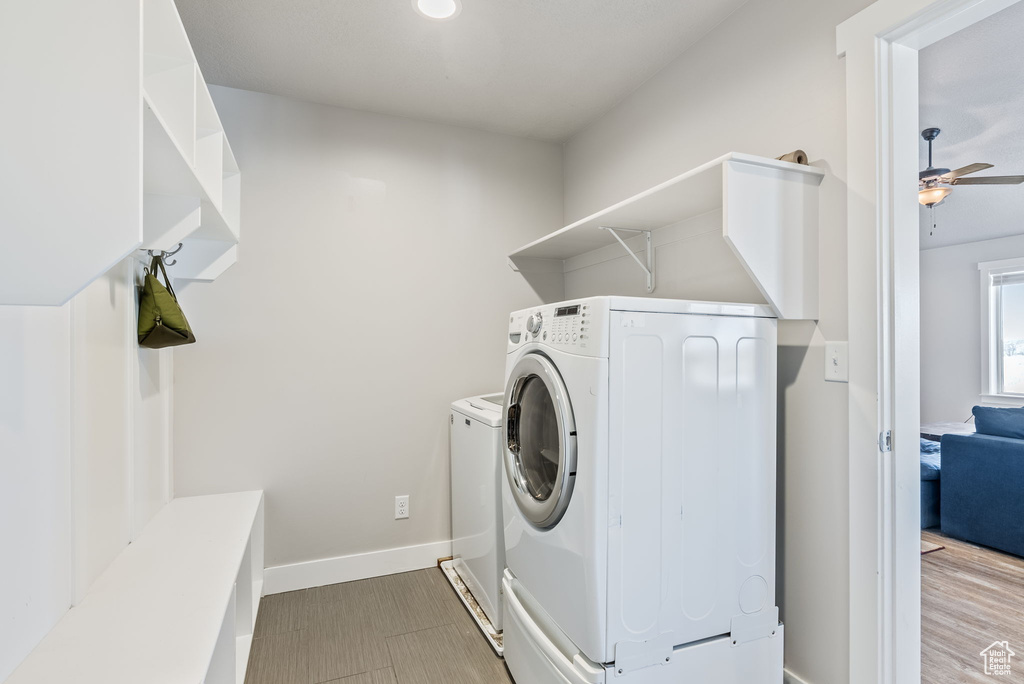Laundry area featuring washing machine and dryer, light tile flooring, and ceiling fan