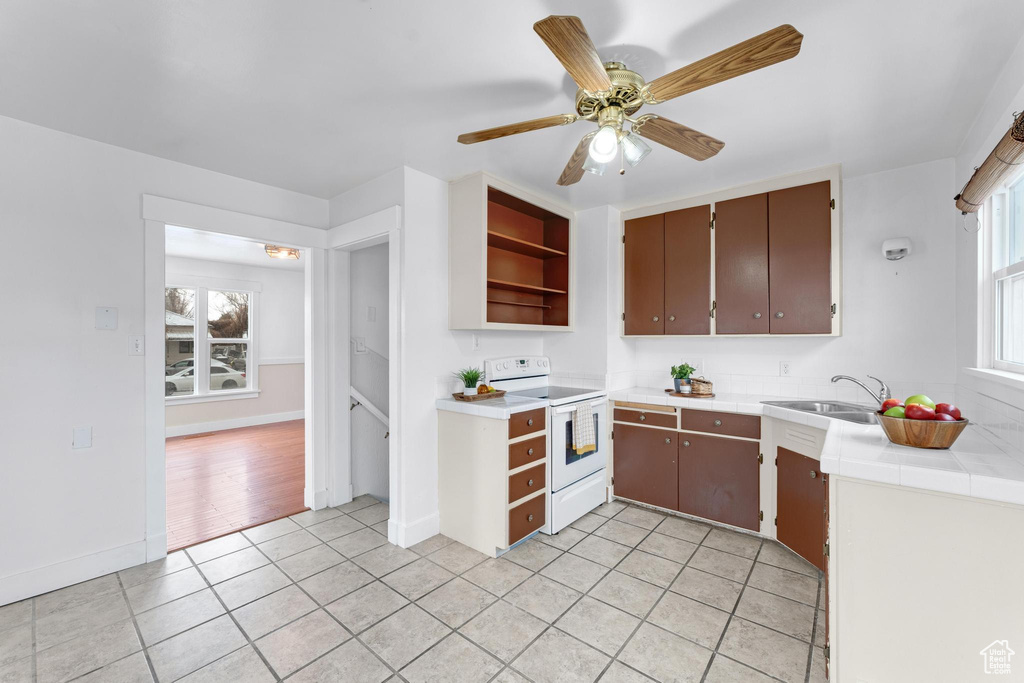 Kitchen featuring light hardwood / wood-style flooring, plenty of natural light, white range with electric cooktop, and ceiling fan
