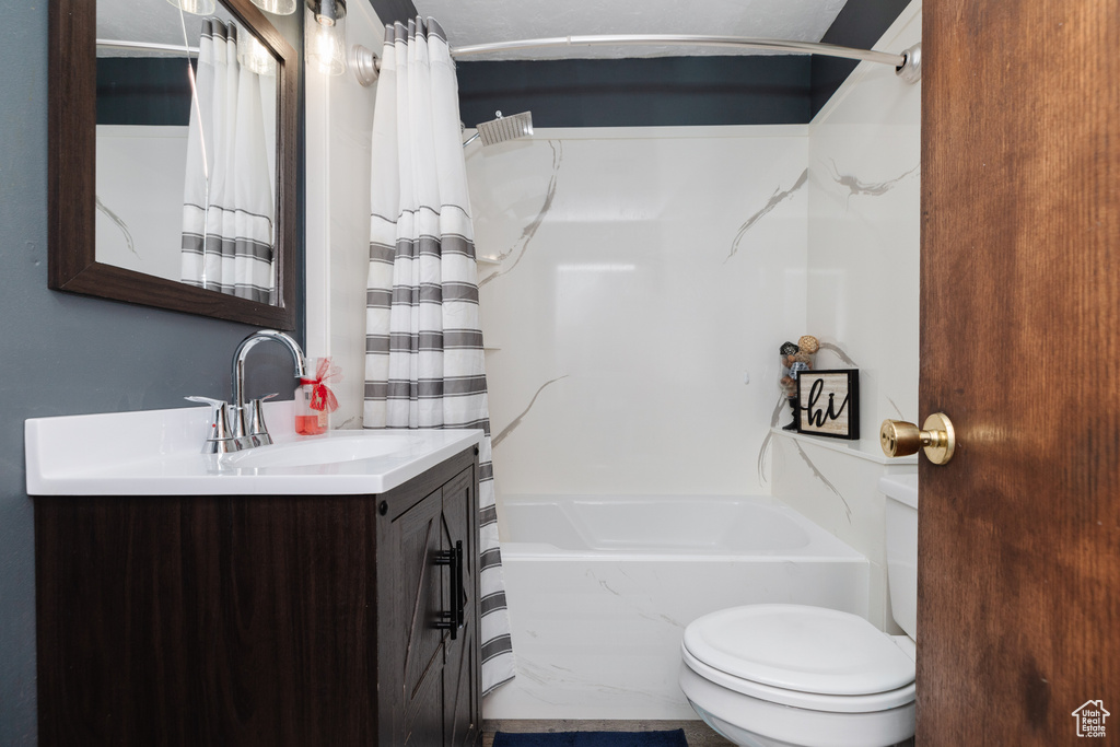Full bathroom with vanity, shower / tub combo with curtain, and toilet