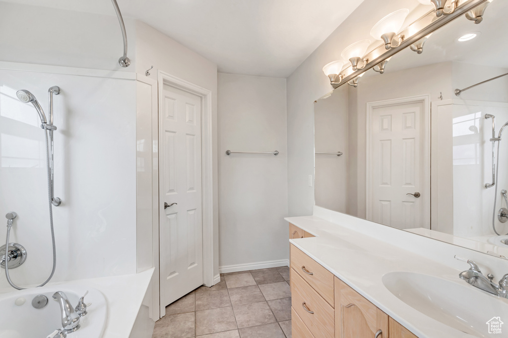 Bathroom with tile flooring, vanity, and shower / bathtub combination