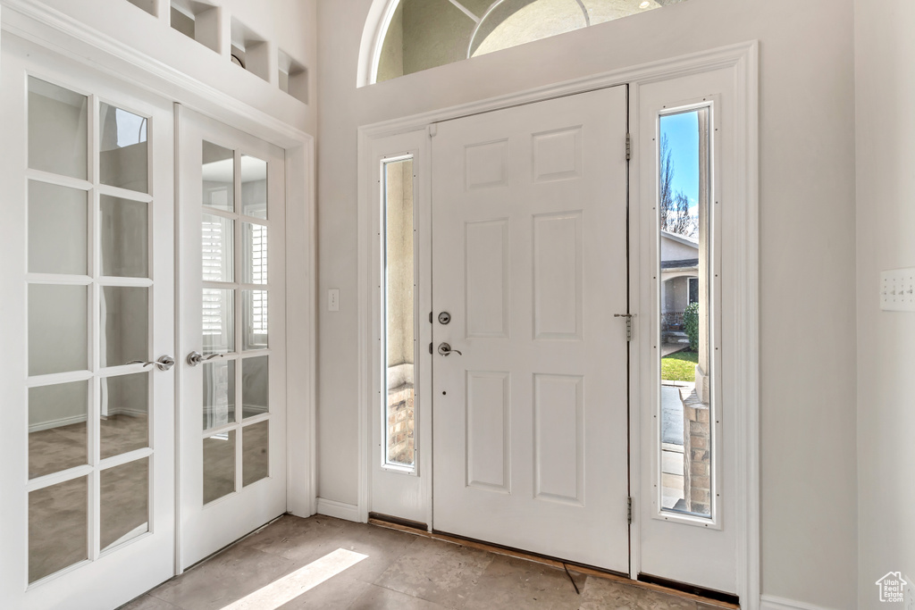 Tiled entrance foyer featuring a wealth of natural light and french doors