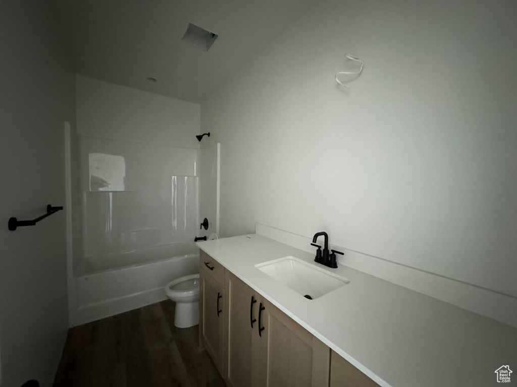 Full bathroom featuring shower / bathing tub combination, toilet, hardwood / wood-style flooring, and vanity