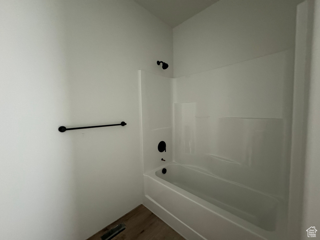 Bathroom with hardwood / wood-style flooring and tub / shower combination