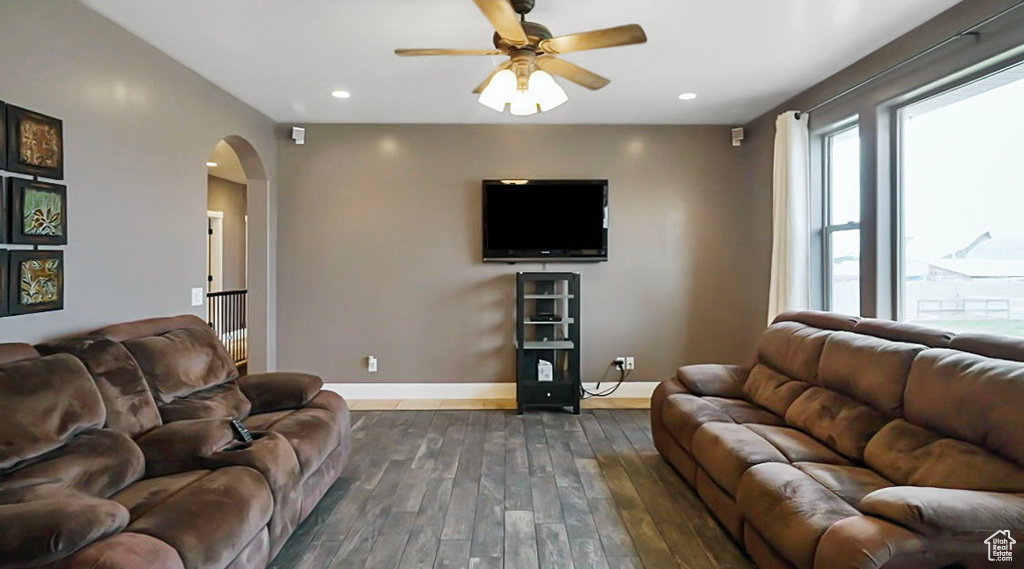 Living room with ceiling fan and dark hardwood / wood-style floors