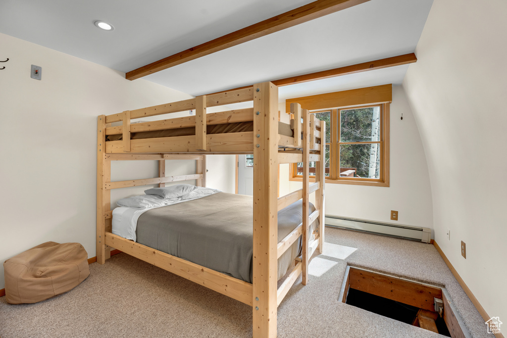 Bedroom featuring a baseboard heating unit, beam ceiling, and light colored carpet