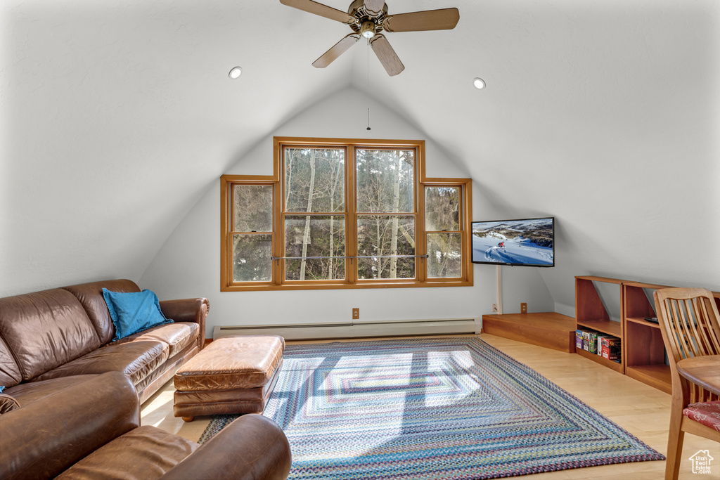 Living room featuring light hardwood / wood-style flooring, lofted ceiling, a baseboard heating unit, and ceiling fan
