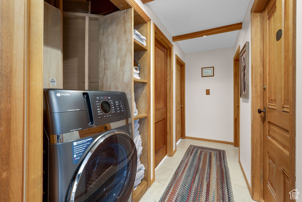 Laundry area with washer / dryer and light tile flooring