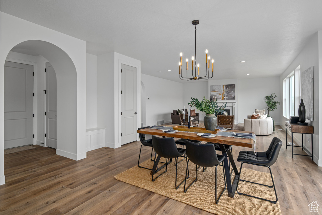 Dining space featuring a notable chandelier and dark wood-type flooring