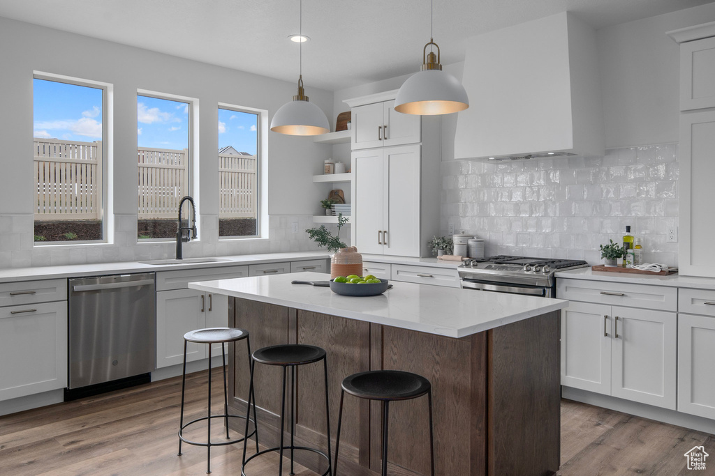 Kitchen featuring pendant lighting, stainless steel appliances, and backsplash