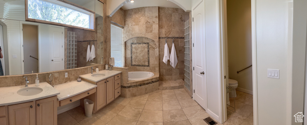 Bathroom with a bathing tub, tile flooring, double sink vanity, and toilet
