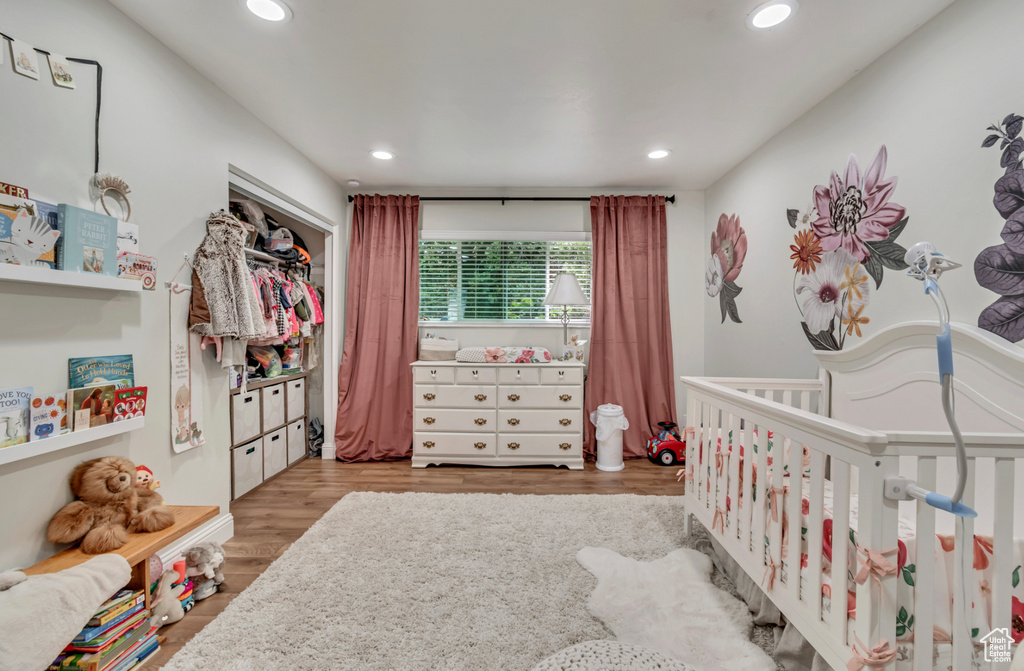 Bedroom featuring a nursery area and light hardwood / wood-style flooring