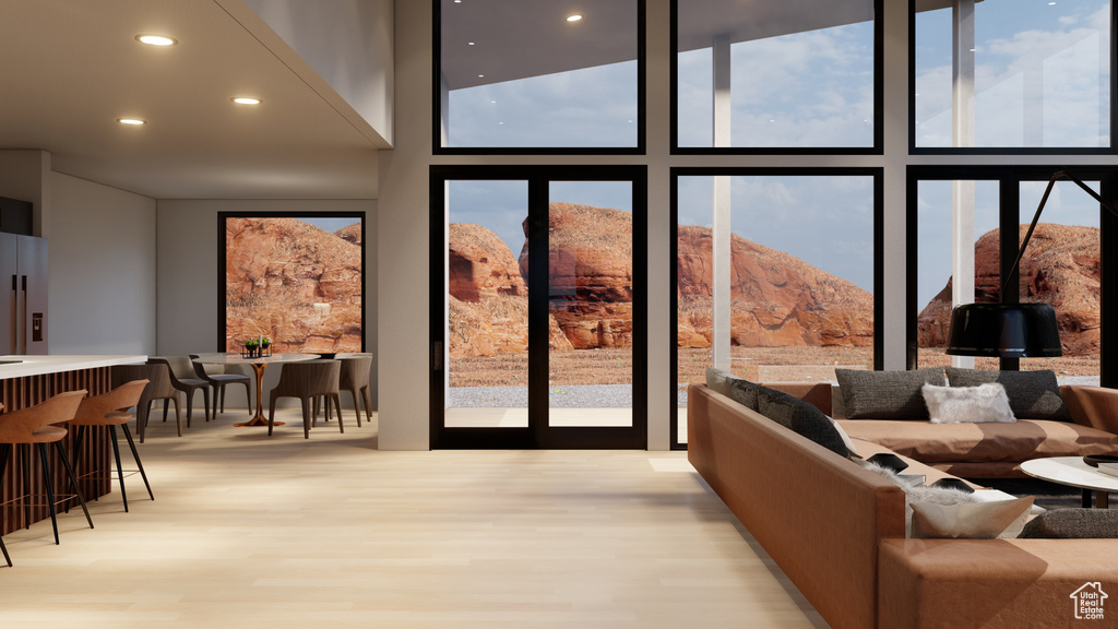 Interior space featuring light hardwood / wood-style flooring, a mountain view, and a wall of windows