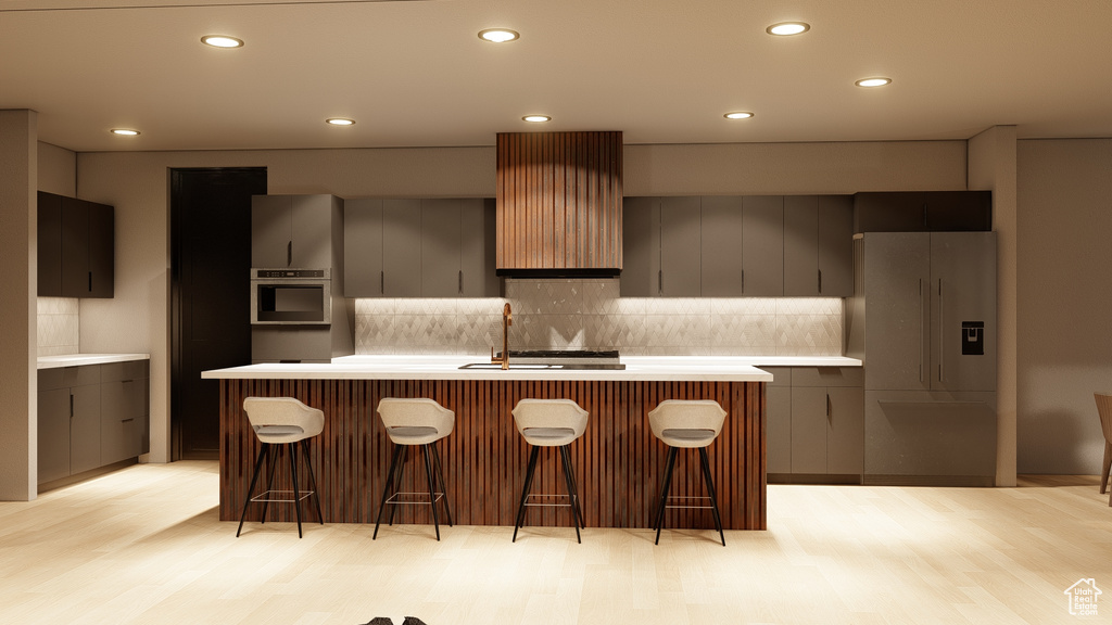 Kitchen featuring a breakfast bar area, white refrigerator with ice dispenser, light hardwood / wood-style flooring, and backsplash