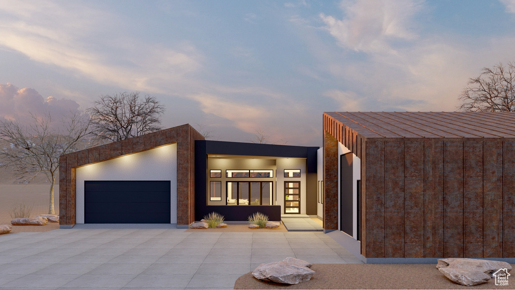 Contemporary home featuring an attached garage and concrete driveway