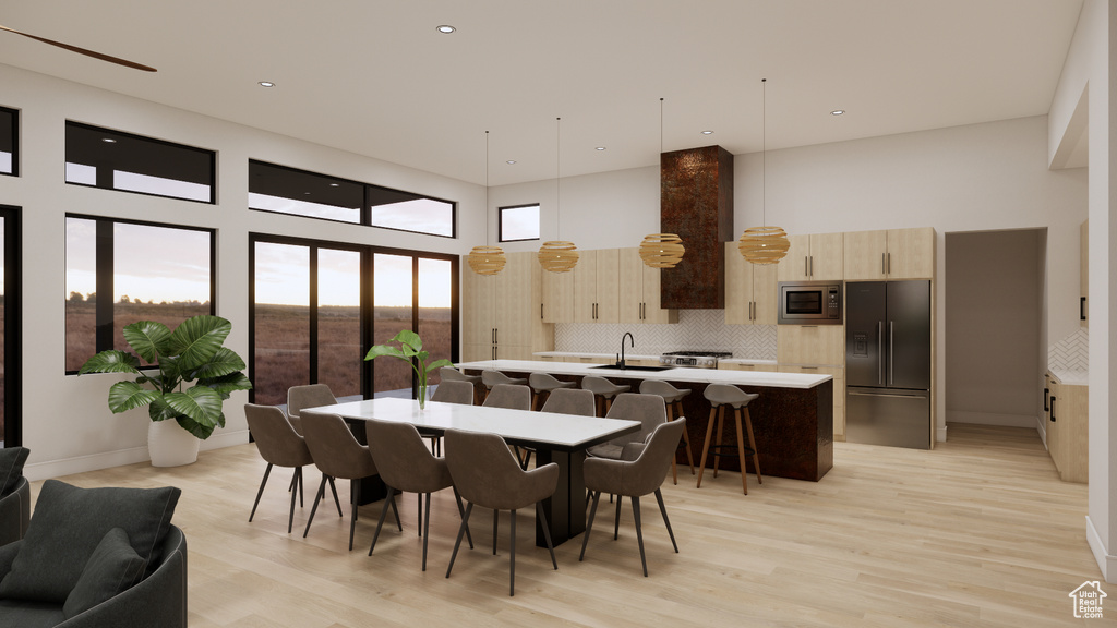 Dining area featuring a high ceiling, light wood finished floors, and recessed lighting