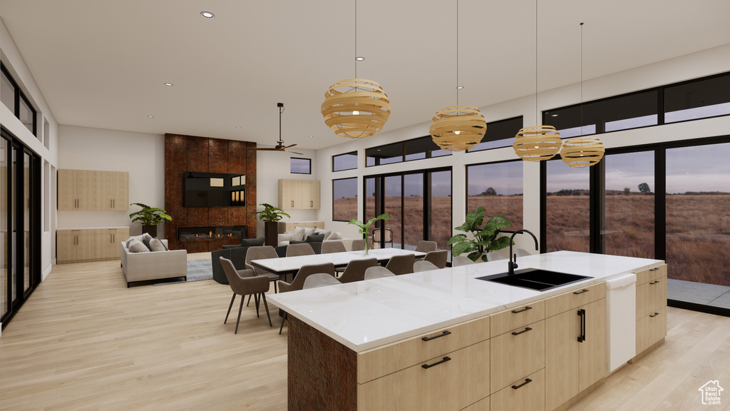 Kitchen featuring light brown cabinets, ceiling fan, light wood-type flooring, modern cabinets, and a large island