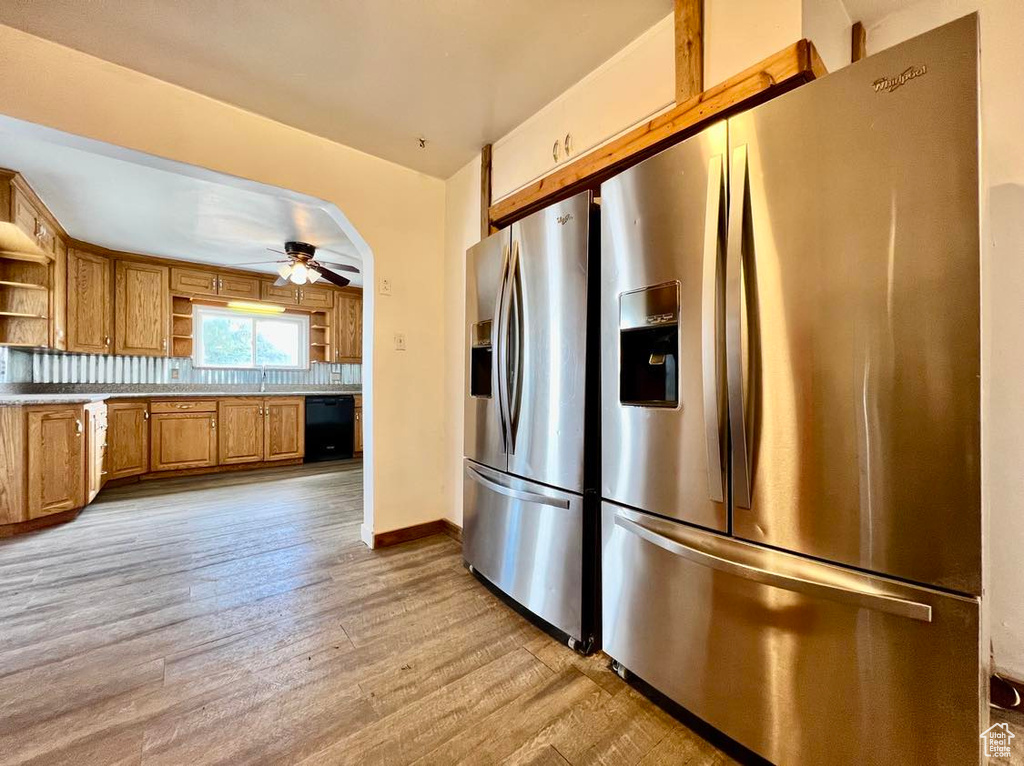 Kitchen featuring stainless steel fridge, light hardwood / wood-style floors, ceiling fan, and dishwasher