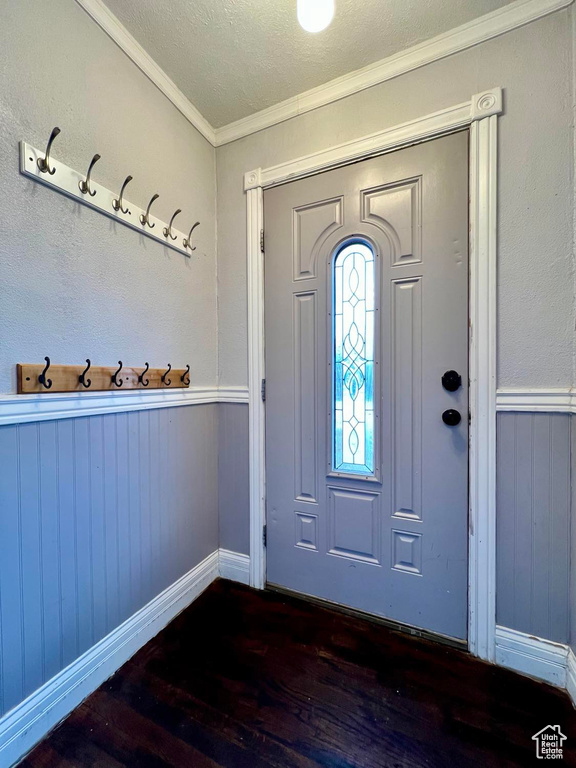Foyer featuring a textured ceiling, dark hardwood / wood-style flooring, and ornamental molding