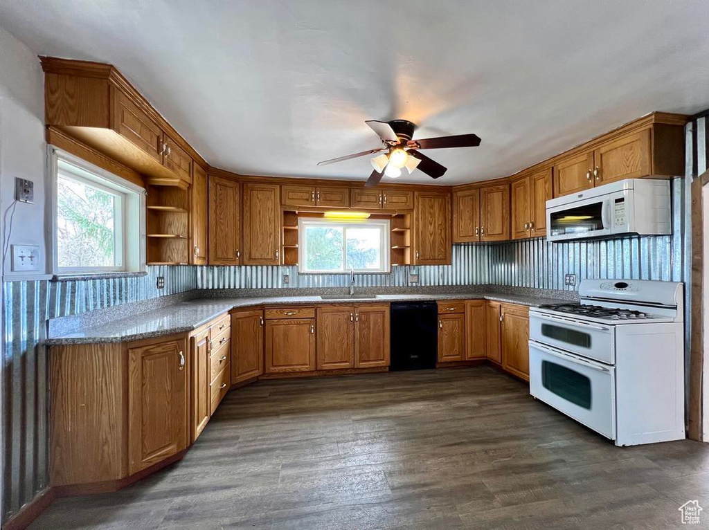 Kitchen featuring white appliances, dark wood-type flooring, ceiling fan, and sink