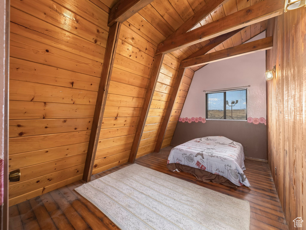 Bedroom with lofted ceiling with beams, wooden ceiling, and dark wood-type flooring