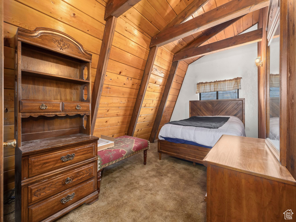 Carpeted bedroom featuring wood ceiling and vaulted ceiling with beams