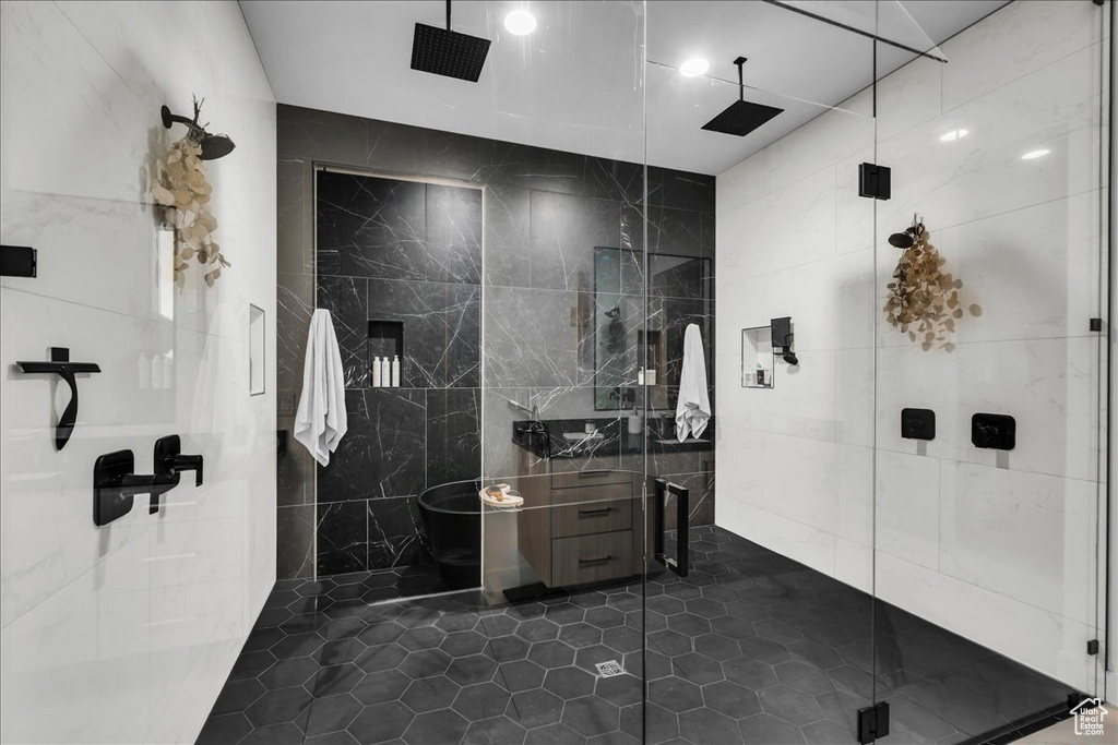 Bathroom featuring tile walls, tile floors, and an enclosed shower