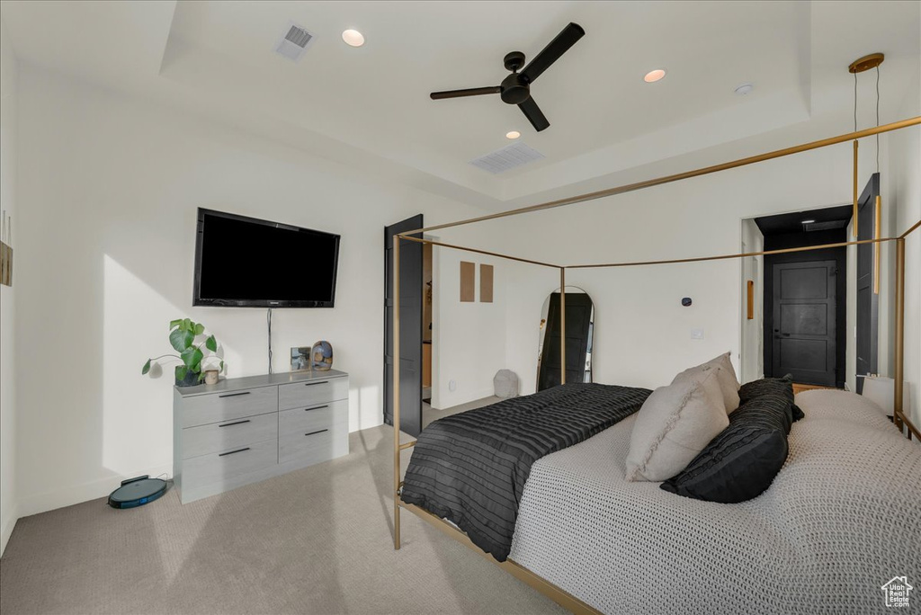 Bedroom featuring a raised ceiling and ceiling fan