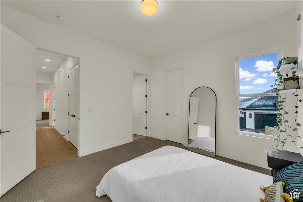 Bedroom featuring dark carpet and multiple windows