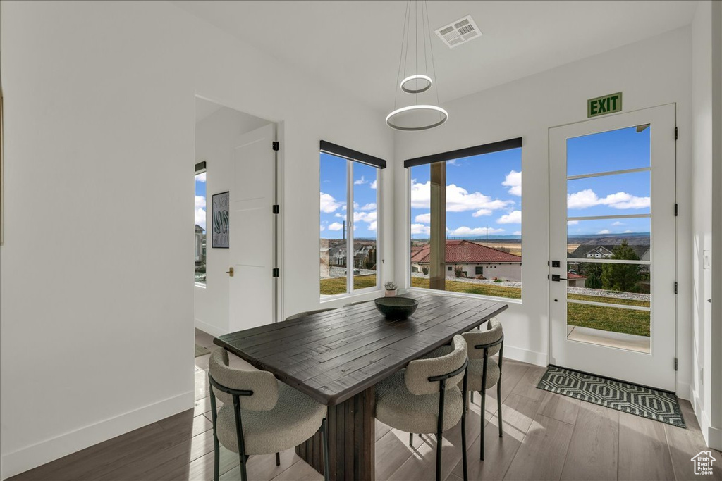 Dining room with dark hardwood / wood-style flooring and a chandelier