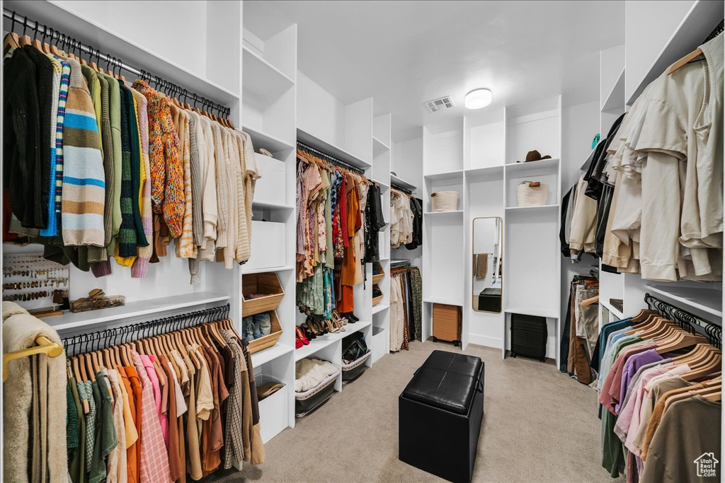 Walk in closet featuring light colored carpet