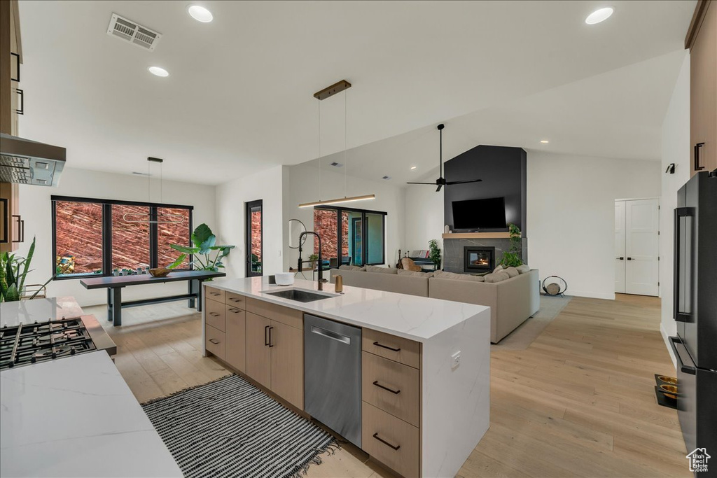 Kitchen with light hardwood / wood-style floors, ceiling fan, and pendant lighting