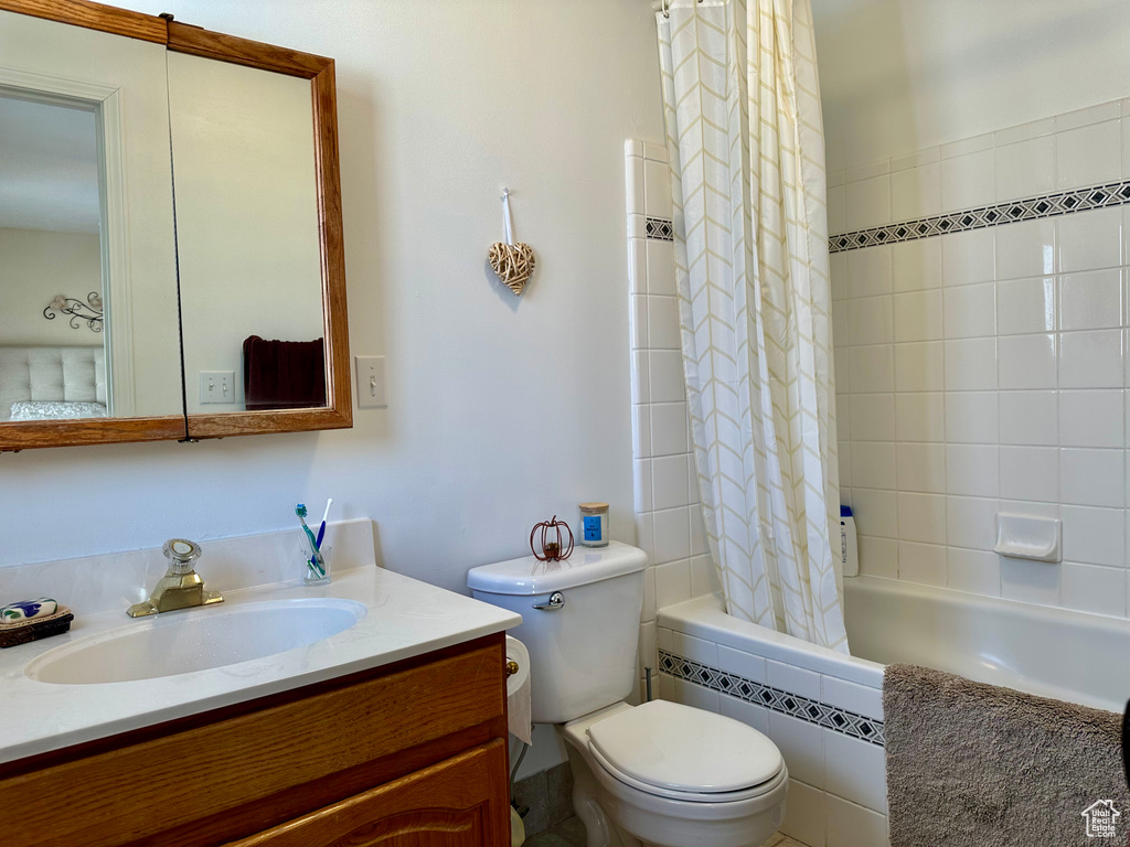 Full bathroom featuring shower / tub combo, oversized vanity, and toilet