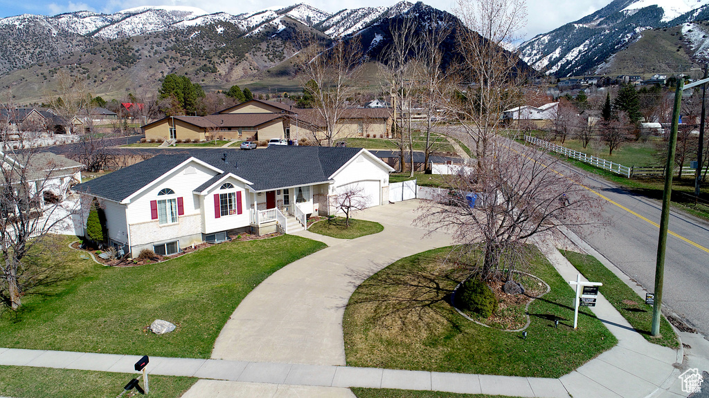 View of front of property featuring a front yard, a mountain view, and a garage