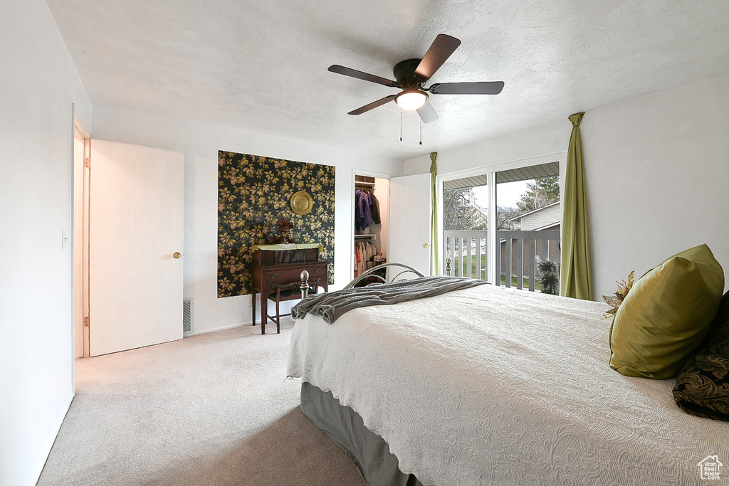 Carpeted bedroom with a closet, ceiling fan, and access to outside