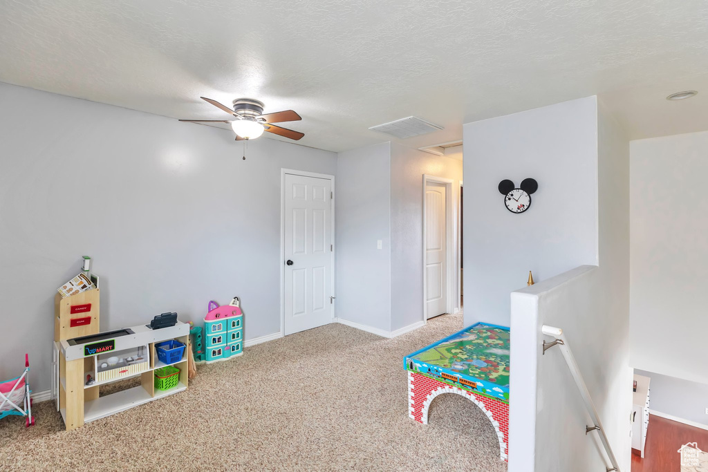 Playroom featuring light carpet, a textured ceiling, and ceiling fan