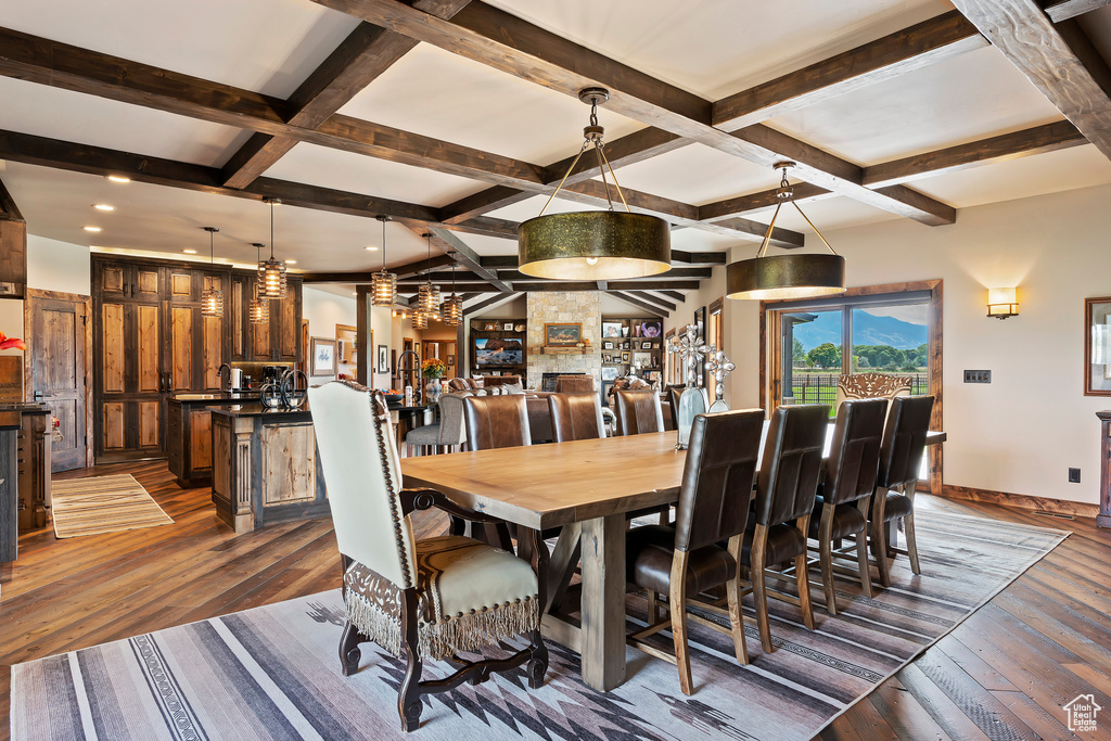 Dining room featuring an inviting chandelier, beam ceiling, dark hardwood / wood-style flooring, and coffered ceiling