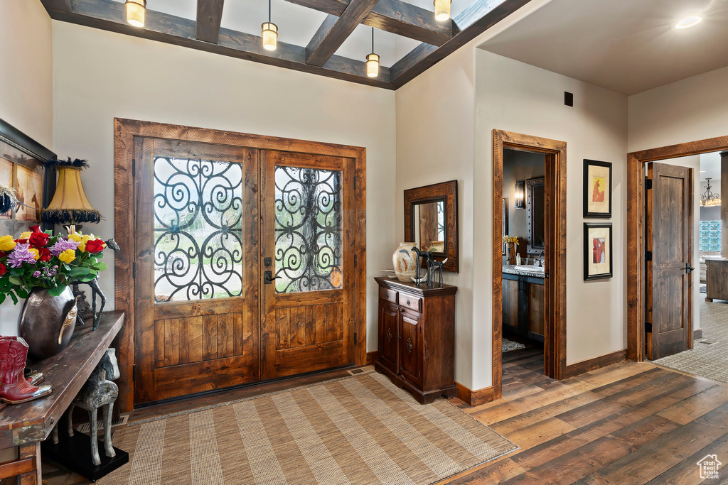 Entryway with french doors, beam ceiling, and dark wood-type flooring