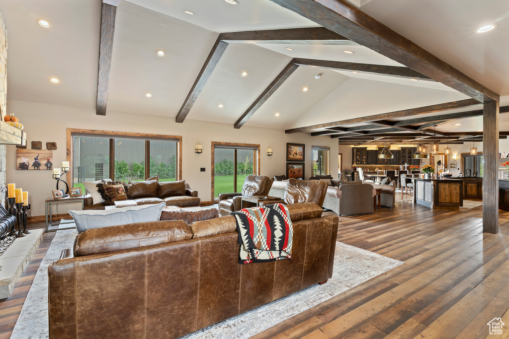 Living room with lofted ceiling with beams and dark hardwood / wood-style flooring