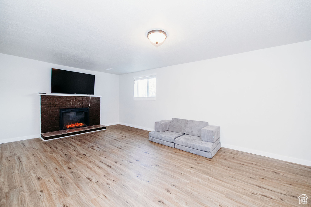 Interior space featuring a brick fireplace and light wood-type flooring